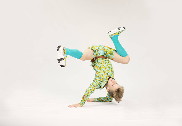 młody chłopiec w wyjątkowej pozycji breakdance, tancerz performance - Zdjęcie, obraz