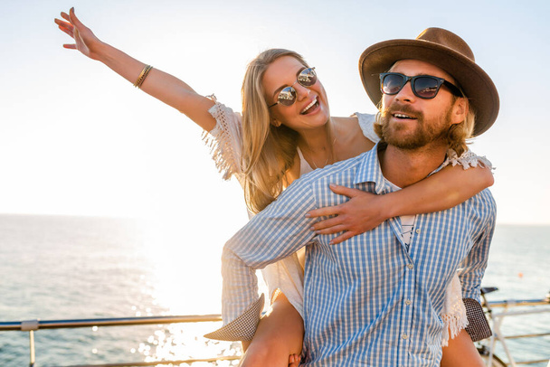attractive happy couple laughing traveling in summer by sea, man and woman wearing sunglasses, boho hipster style fashion having fun together - Foto, afbeelding