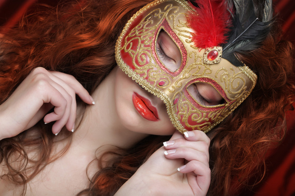 Young woman in a red mysterious mask - Фото, изображение