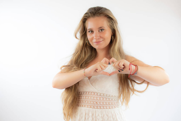 Girl in white dress making heart figure with her hands - Photo, Image