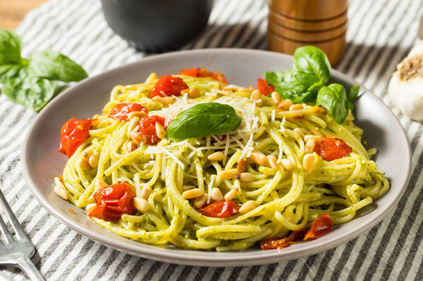 Healthy Homemade Basil Pesto Pasta with Tomatoes and Pine Nuts - 写真・画像