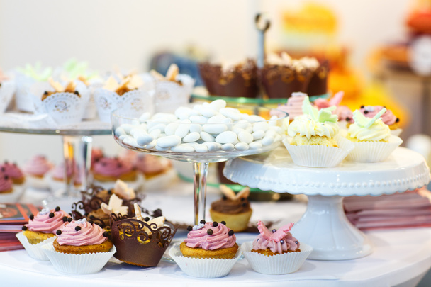 κομψό γλυκό πίνακα με cupcakes, κέικ σκάει και καραμέλα για δείπνο - Φωτογραφία, εικόνα