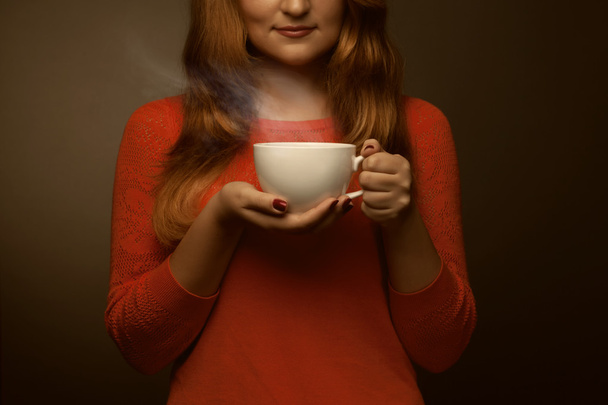 woman holding hot cup and smiles - Foto, Bild