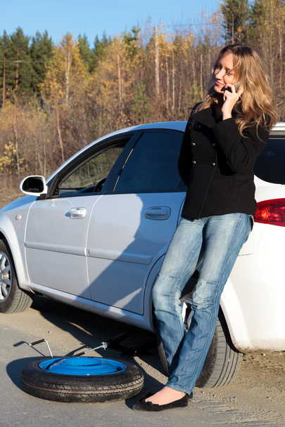 Jovem mulher em pé perto de seu carro danificado
 - Foto, Imagem