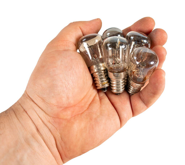 Alguma lâmpada incandescente de tungstênio velho na mão. Imagem isolada sobre fundo branco
. - Foto, Imagem