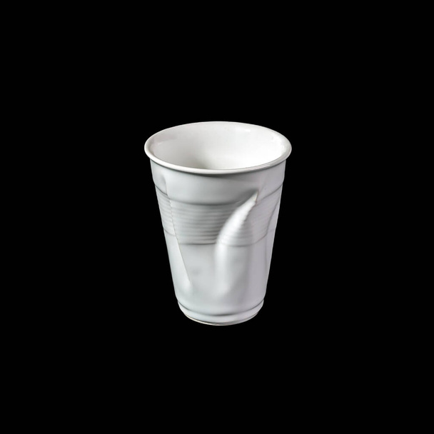 Crumpled white disposable paper plastic cup isolated on black background. - Photo, Image