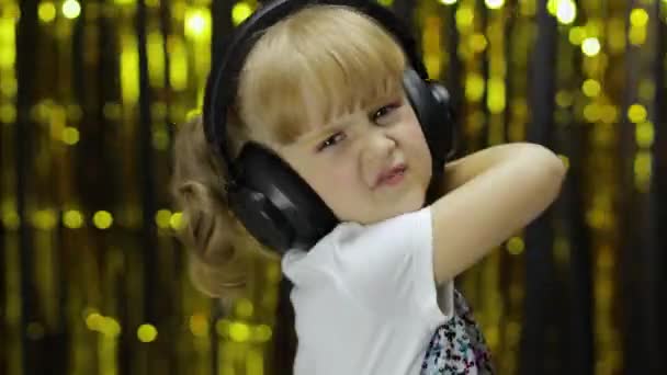 Child dances, sings, listens music on headphones. Little kid girl having hun, relaxing and enjoying - Footage, Video