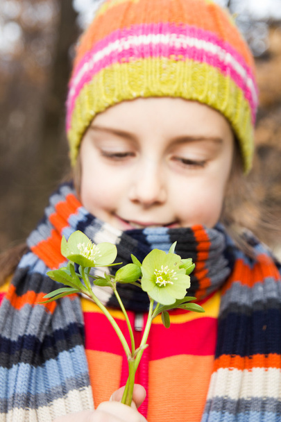 Niña bonita sosteniendo flor de helleborus - La primavera está aquí
 - Foto, Imagen