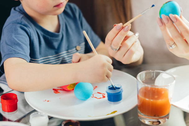 Happy Easter Young mother and her little son painting Easter eggs. - Foto, Bild