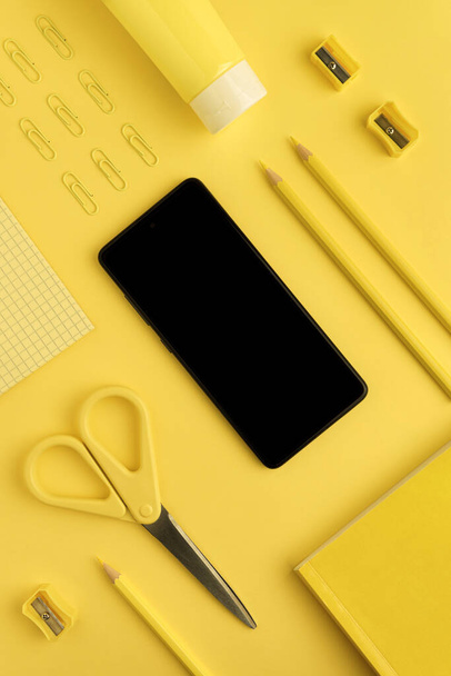 Black smartphone mockup, pencils, paper clips, scissors, pencil sharpeners - Фото, изображение
