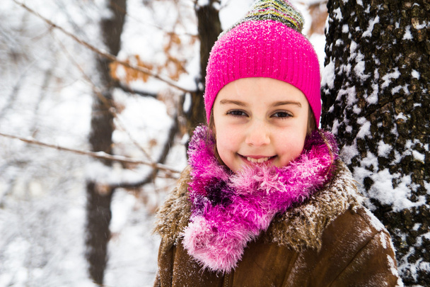 Happy little girl spending a nice time in winter forest - Photo, Image
