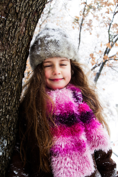 Happy little girl spending a nice time in winter forest - Valokuva, kuva