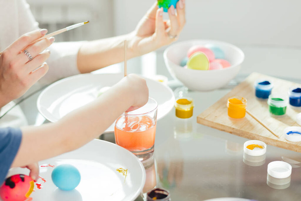 Happy Easter Young mother and her little son painting Easter eggs. - Foto, Imagen