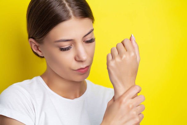 Young woman feels severe pain in her hand - Foto, Bild