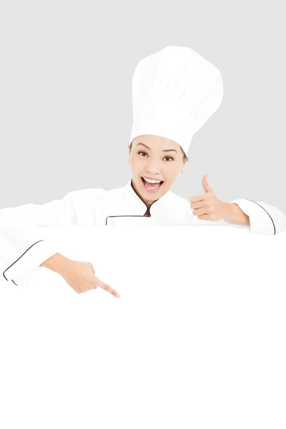 joven mujer chef sonriendo y pulgar hacia arriba con tablero en blanco
 - Foto, Imagen