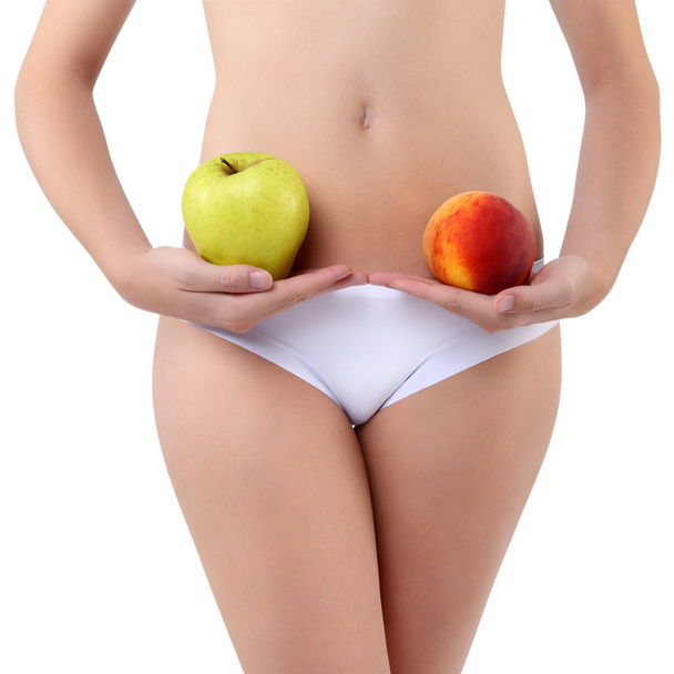 woman holding an apple and peach with his hands near the belly - Foto, Imagem