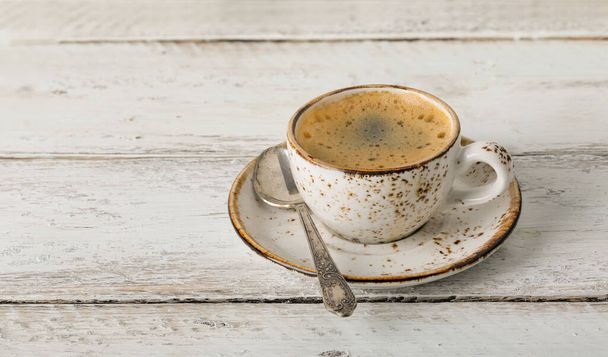 Tazza di caffè leggero su un vecchio tavolo di legno primo piano, caffè del mattino - Foto, immagini