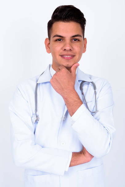 Studio shot of young handsome multi ethnic man doctor against white background - Photo, Image