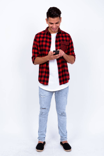 Studio shot of young handsome multi ethnic hipster man against white background - Foto, imagen