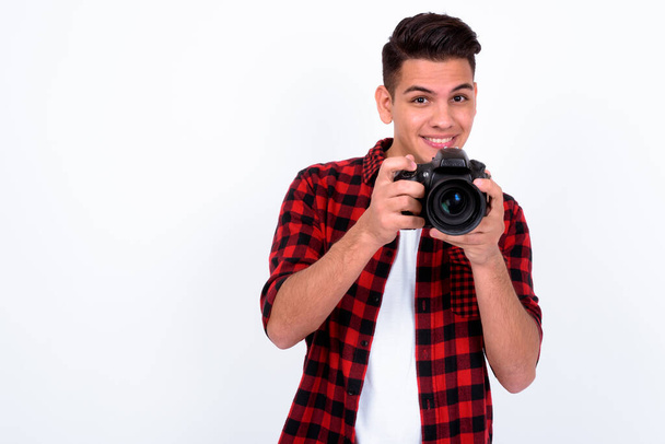 Studio shot of young handsome multi ethnic hipster man against white background - 写真・画像