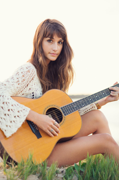 Beautiful young woman playing guitar on beach - Fotoğraf, Görsel
