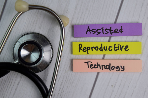 Asszisztált reprodukciós technológia szöveg ragacsos jegyzetek irodai íróasztallal. Egészségügyi / orvosi koncepció - Fotó, kép