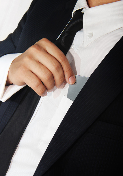 Businessman holding a blank card from his pocket - 写真・画像