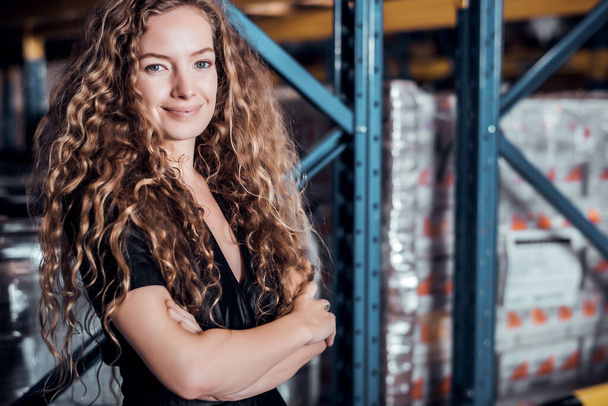 Confident Caucasian woman owner standing and crossed her arm at goods warehouse store and check for control loading containers box from Cargo freight ship for import and export  - Photo, Image