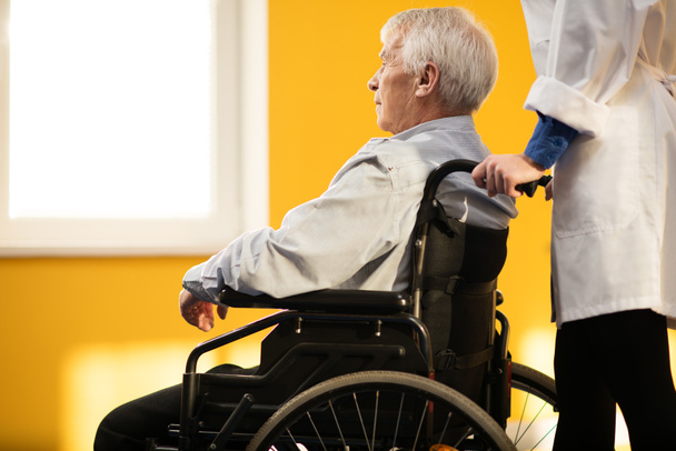 Enfermeira mulher com homem idoso em cadeira de rodas r
 - Foto, Imagem