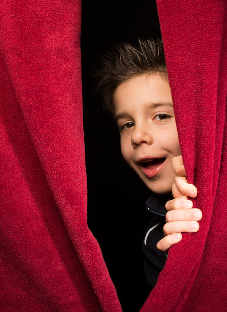 Child appearing beneath the curtain - Фото, изображение