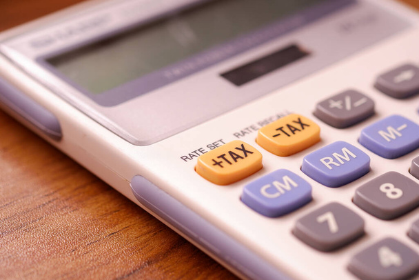 Concentrare il pulsante delle tasse sulla calcolatrice. Nozione di calcolo e rimborso annuale delle imposte. - Foto, immagini