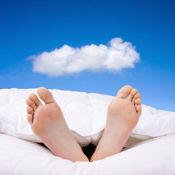 zwei nackte Füße, die glücklich im Bett liegen - Foto, Bild