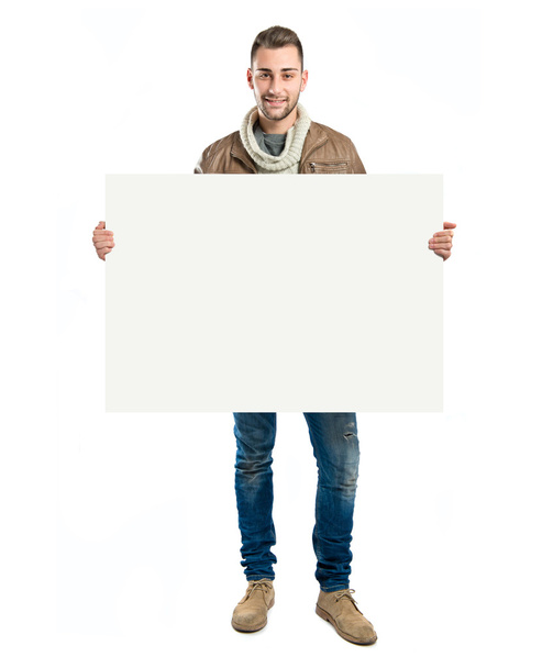 handsome man holding an empty cardboard over white background - Foto, Imagem