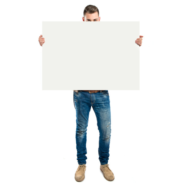 handsome man holding an empty cardboard over white background - Fotó, kép