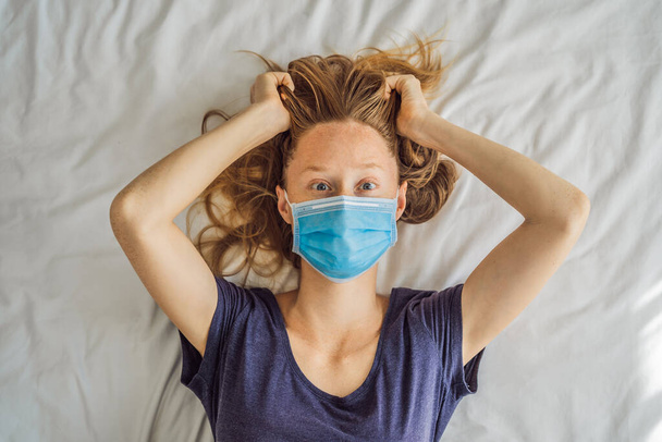 Extremly tired young woman lying on the bed, home alone. self-isolation at home, quarantine due to pandemic COVID 19. Mental health problems in self-isolation at home - Fotoğraf, Görsel