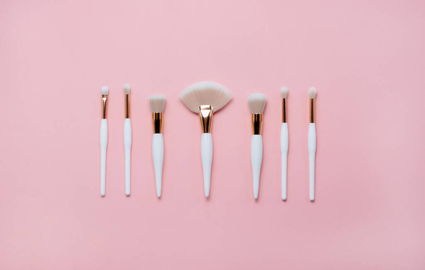 Makeup brushes and flowerss on white background. Top Horizontal view copyspace. - Photo, Image