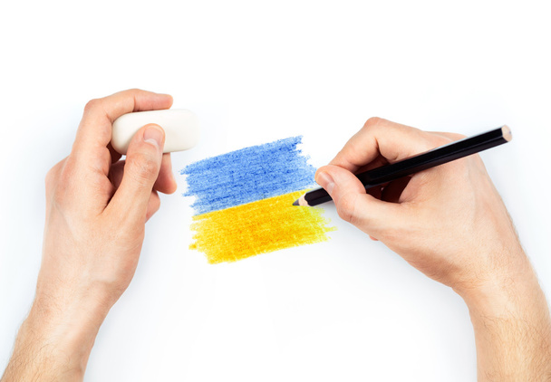 Man's hands with pencil draws flag of Ukraine on white - Fotó, kép