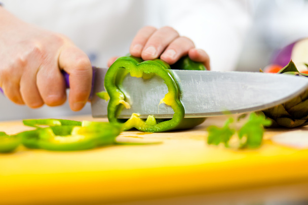 Chef cutting a green pepper - Φωτογραφία, εικόνα