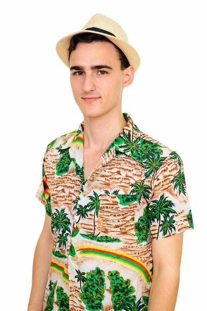 Studio shot van jonge knappe toerist met Hawaïaans shirt klaar voor vakantie geïsoleerd tegen witte achtergrond - Foto, afbeelding