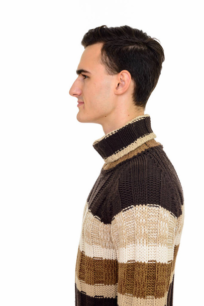 Studio shot of young handsome man with turtleneck sweater ready for winter isolated against white background - 写真・画像