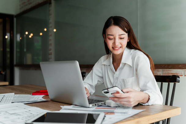 Hosszú haj tervező nő fehér ing ül az irodában olvassa az üzenetet barátja munka közben. - Fotó, kép