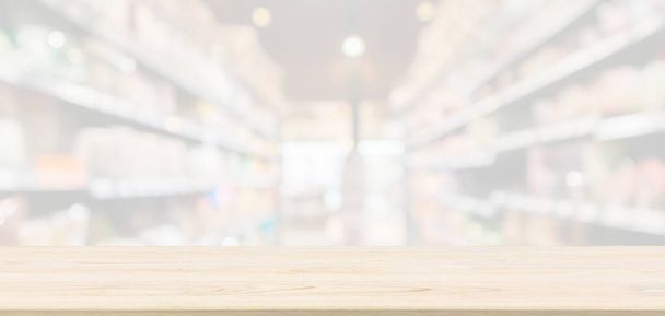 Tampo de mesa de madeira vazio com supermercado supermercado corredor de mercearia desfocado desfocado fundo com luz bokeh para exibição de produto de montagem
 - Foto, Imagem