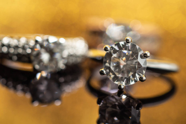 Jewelry wedding diamond ring on golden background with reflection - Foto, Bild