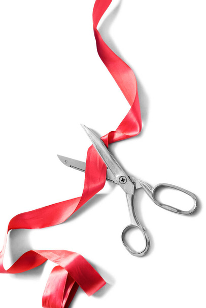 Scissors cut red silk ribbon on white background - Fotografie, Obrázek
