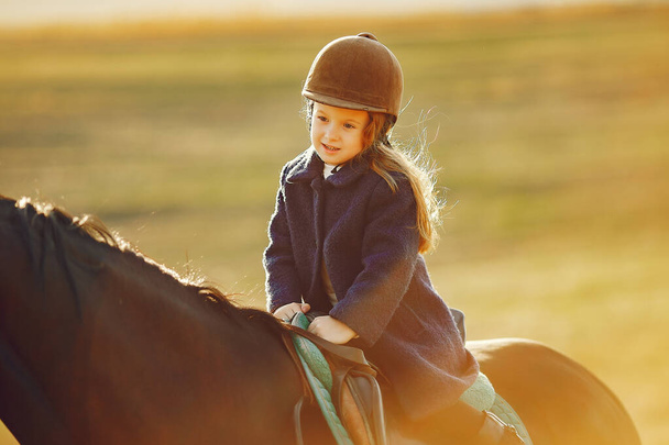 Cute little girl in a autumn field with horse - Fotografie, Obrázek