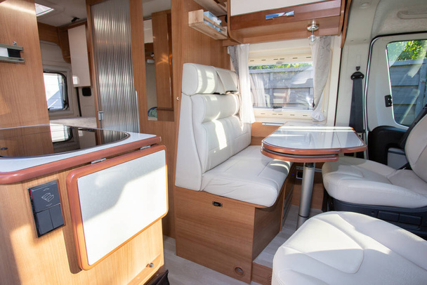 rv Camper Dining Room area with wooden white luxury interior in motor home van during vanlife - Foto, afbeelding