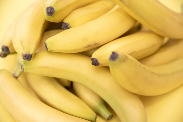 Желтые бананы на желтом фоне. Свежие вкусные ароматизированные натуральные бананы. Натуральный продукт. Диета. - Фото, изображение