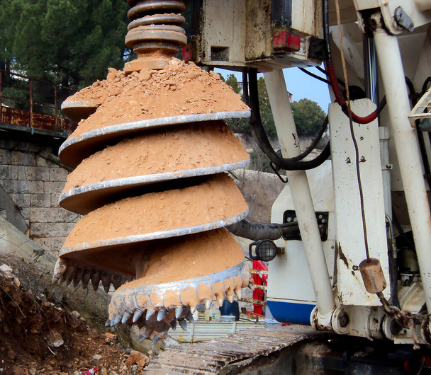 maquinaria de servicio pesado utilizado para perforar agujeros en el suelo en el sitio de construcción. Detalles de construcción de carreteras con máquina perforadora rotativa - Foto, imagen