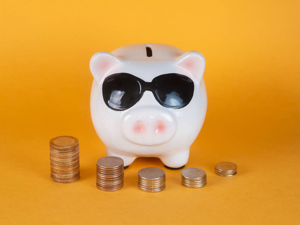 Cute piggy bank and coins.yellow background. Money saving concept. - Foto, immagini