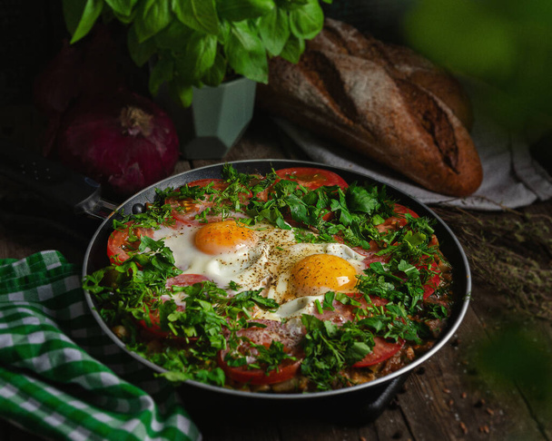 Excellent breakfast (lunch) - shakshuka. Fried eggs with vegetables in a frying pan. Rustic simple dishes made from farm products - Photo, Image